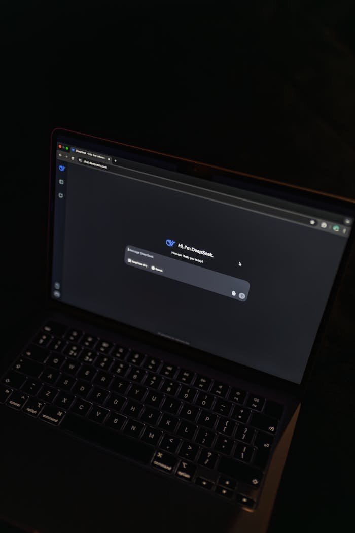 A MacBook displaying an AI chat interface in a dimly lit setting, showcasing modern technology.